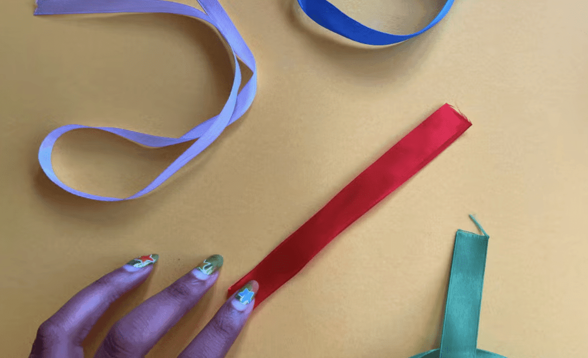 Step_2_Fold_the_Ribbon_in_Half_and_Press_at_the_Center_to_Create_a_Crease